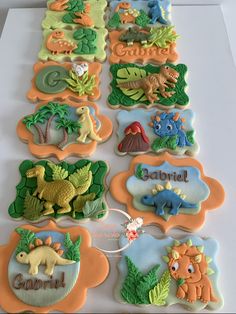 decorated cookies are arranged in the shape of animals and plants, with name tags on them