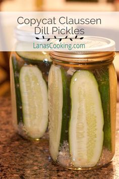 two jars filled with pickles sitting on top of a counter