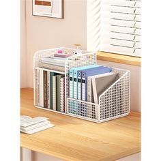 a desk with a book shelf filled with books and binders next to a window