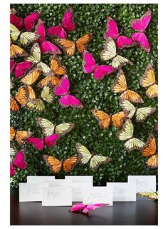 there are many pink and yellow butterflies on the wall