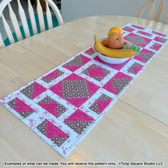 a table runner with a bowl of fruit on it and a banana in the center