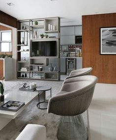 a living room filled with furniture and a flat screen tv on top of a wooden wall