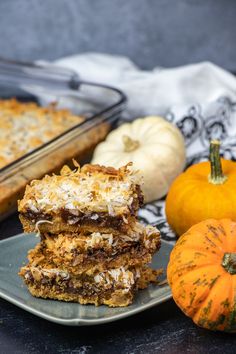 three pieces of cake sitting on top of a plate next to pumpkins and other food