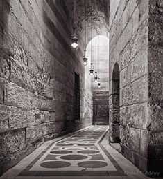 an alley way with stone walls and lights