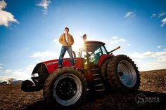 a man standing on top of a red tractor