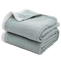 two blankets folded on top of each other in light green and white colors, one is folded