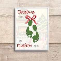 christmas wishes and mistlet kisses card with red ribbon on it, sitting on a wooden surface