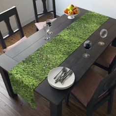 the table is set with two place settings and silverware, along with an empty bowl of fruit