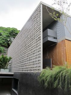 the building is made out of concrete and has plants growing on the outside wall next to it