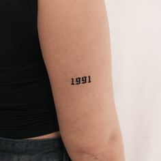 a person with a tattoo on their arm that reads, 1911 written in black ink