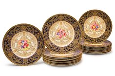 a set of four plates with gold and blue designs on the front, one plate has an image of a woman holding a flower in her left hand