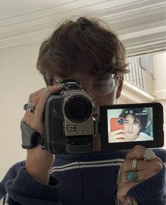 a person taking a selfie in front of a mirror with a camera on it