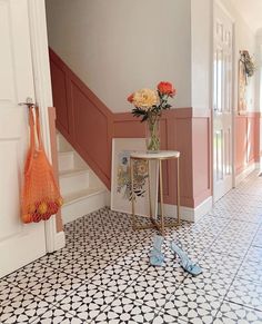 a vase with flowers sitting on top of a table next to a pair of shoes