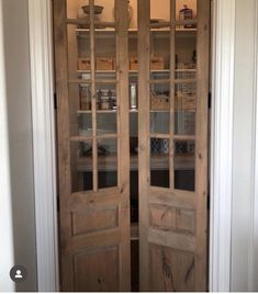 an open wooden door with glass panels in the middle and shelves on either side behind it