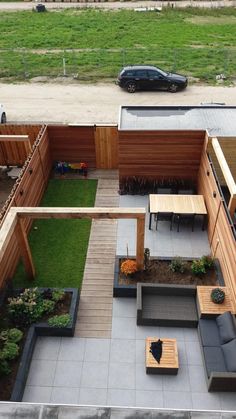 an overhead view of a backyard with wooden furniture and green grass in the back yard