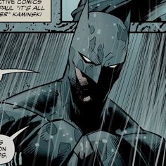 the batman is standing in the rain