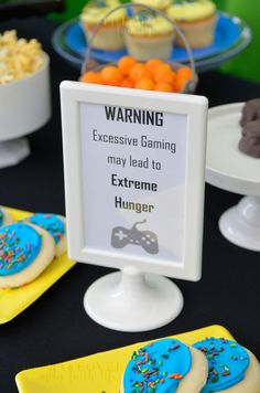 a table topped with cookies and cupcakes covered in frosting on top of plates