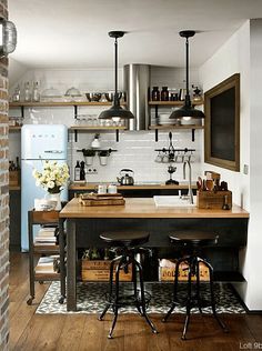 a kitchen with two stools in front of an island and shelves above it,