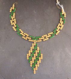 Item oxfj8 Price £125 Circa 1960 Wow this is an absolutely fabuuuuuulous necklace. This piece has a bold profile with vibrant emerald green stones and gold tone flowers, in a link design that moves and adjusts to your neckline when worn. The necklace has a substantial weight and feel and lies flush along your neckline when worn. Overall this is a well made and uniquely designed necklace. The diamond pendant measures approx. 8.5x4.5cm, the necklace measures 31cm extending to 35cm, 1.5cm wide. Green Jeweled Necklaces For Anniversary, Green Jeweled Necklace For Anniversary, Party Jewelry In Yellow Gold With Emerald, Yellow Gold Emerald Jewelry For Party, Green Hallmarked Emerald Necklace For Wedding, Evening Yellow Gold Jewelry With Emerald, Evening Yellow Gold Emerald Jewelry, Formal Green Emerald Necklace With Jewels, Green Necklace For May Birthstone