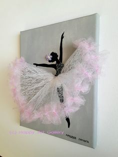 the ballerina is hanging on the wall