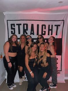 a group of women standing next to each other in front of a white wall with the word straight on it