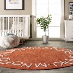 an orange rug with the words welcome home written on it in white letters, and a potted plant