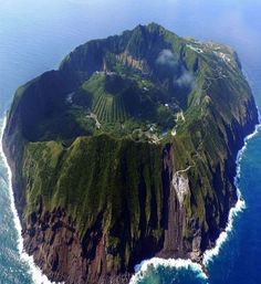 an island in the middle of the ocean with lots of land on top of it