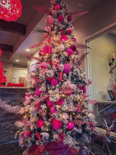 a decorated christmas tree with pink and silver ornaments