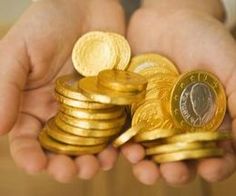 two hands holding stacks of gold coins