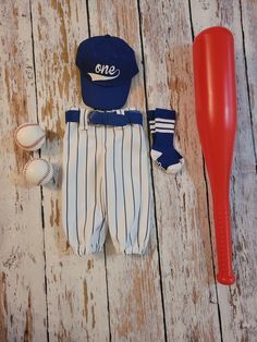 a baseball bat, glove and ball laying on a wooden floor next to a hat