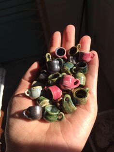 a hand holding several small ceramic objects in it's palm