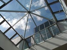 looking up at the sky through an open glass window on a building's roof