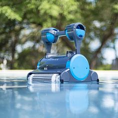 a robotic pool cleaner on the ground with trees in the background