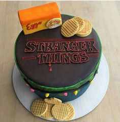 a cake that is sitting on top of a table with cookies and candy in front of it