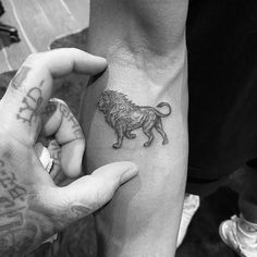 two people holding hands with tattoos on their arms and one has a lion tattoo on the arm