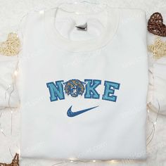 a white shirt with the word nike on it and a lion head in blue letters