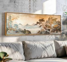 a painting hanging on the wall above a couch in front of a potted plant