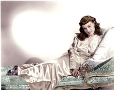 a woman sitting on top of a bed wearing a dress and holding a pillow in her hand