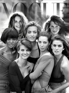 several women posing for the camera in front of a magazine cover with their arms around each other