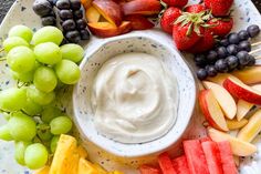 an assortment of fruits and dip on a plate