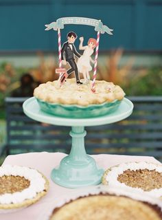 a cake on a table with cookies and an image of a bride and groom holding hands