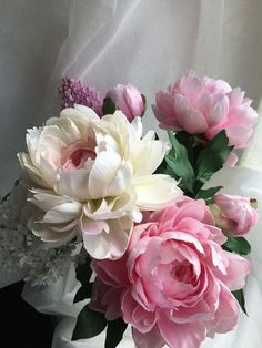 pink and white flowers are in a vase