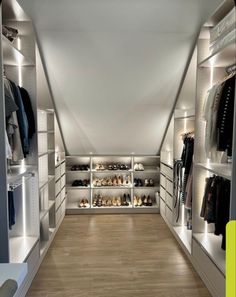 a walk in closet filled with lots of shoes and clothing on shelves next to each other