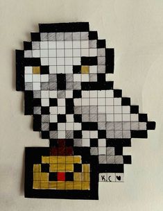 a piece of art made out of legos on a white surface with black and yellow squares