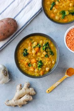 two bowls of soup with carrots, broccoli and cauliflower on the side