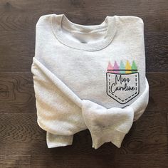 Our Embroidered Custom Crayon Teacher Crewneck is the coziest sweatshirt for all the Teachers! This custom design makes for the perfect gift to show your appreciation. Design is professionally embroidered onto ash grey colored sweatshirt. Customize with your teacher's name, grade or initials. Crayon colors are customizable if requested! S I Z I N G: These are unisex sweatshirts. Small Medium Large XL 2XL 3XL Our sweatshirts are VERY soft and comfy. F A B R I C A T I O N :  Gildan G180 Unisex Hea Future Teacher Shirts, Appreciation Design, School Finds, Machine Embroidery Gifts, Teacher Shoes, Teacher Fits