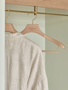 a white shirt hanging on a wooden hanger