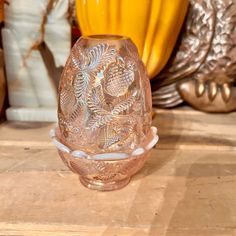 a clear glass vase sitting on top of a wooden table next to other decorative items