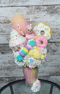 a glass vase filled with donuts, doughnuts and sprinkles