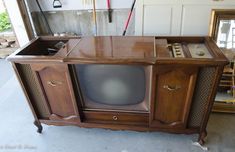 an old tv sitting on top of a wooden cabinet